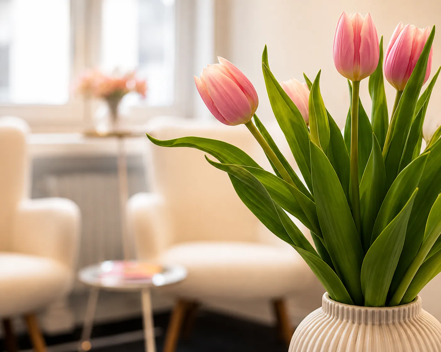 Rosa Tulpen in einer Vase vor den Sesseln des Wartebereichs